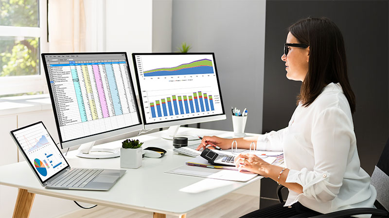 woman sitting at a desk working on project charts